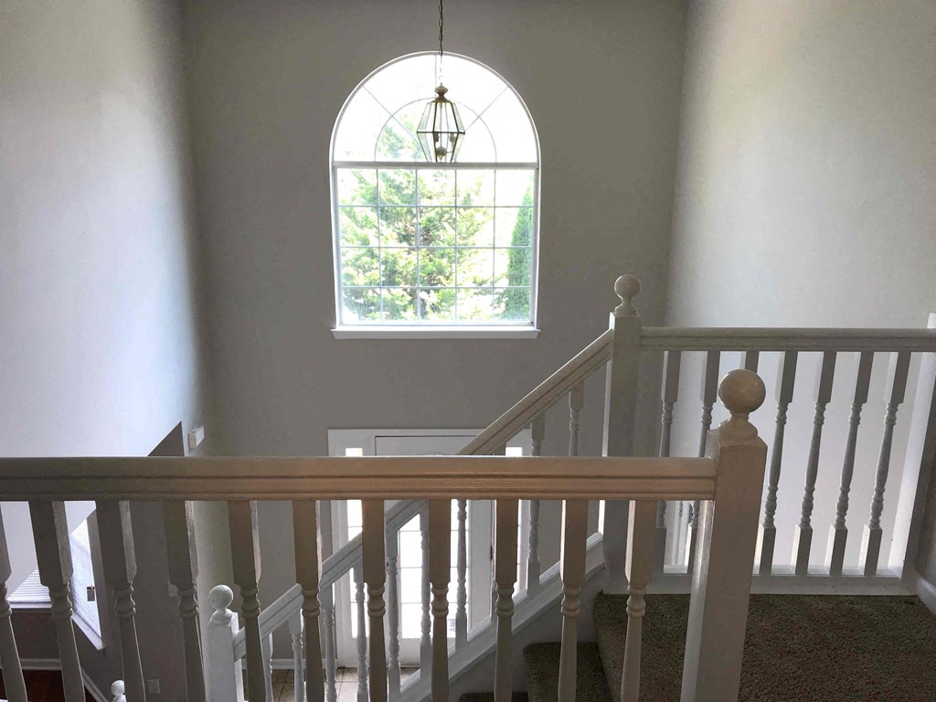 a stairway with a window and a wooden railing