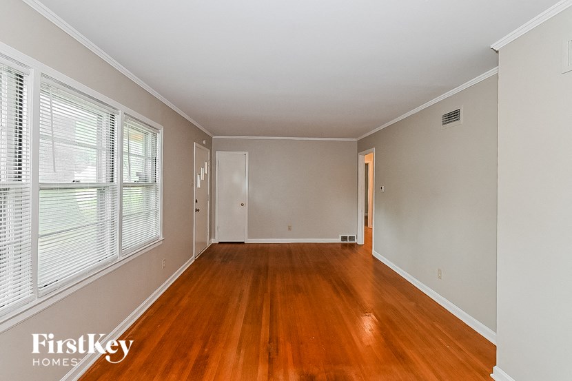 an empty living room with wood floors and a large window