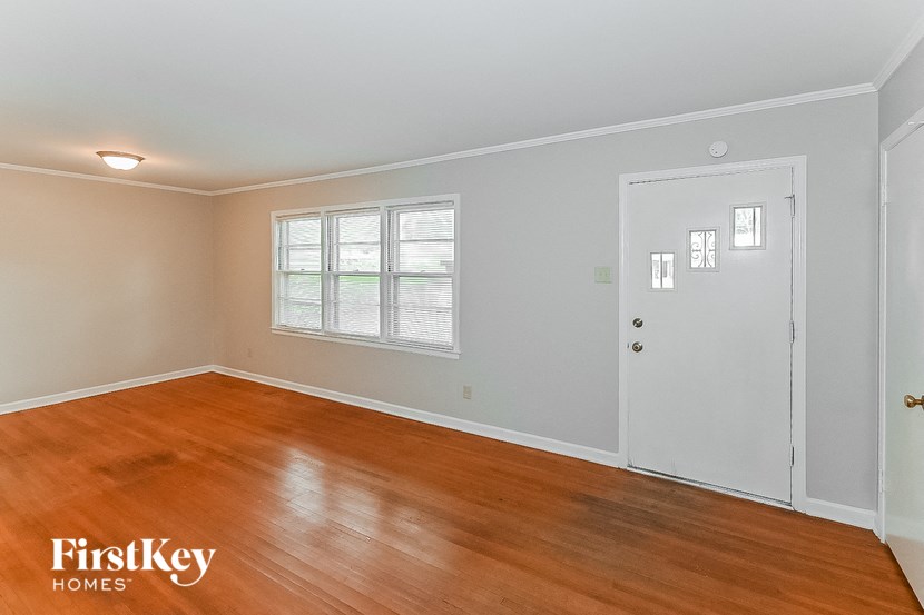 a living room with a wooden floor and a white door