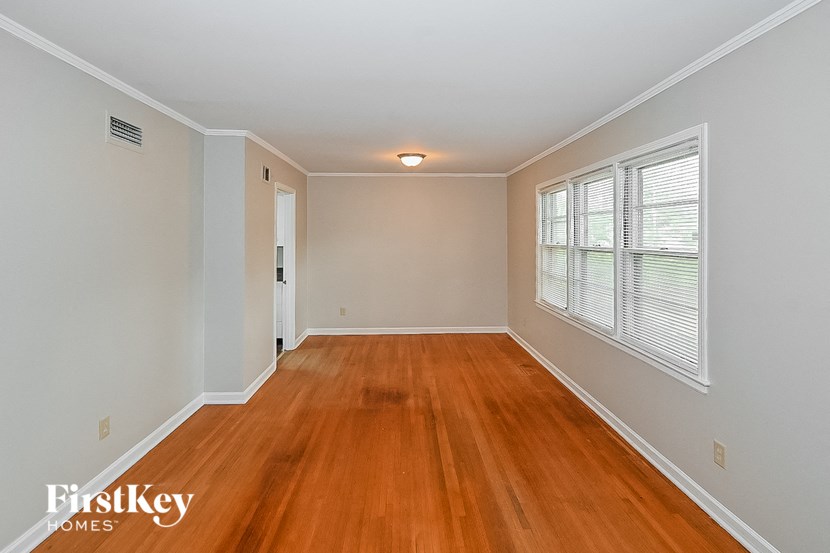 an empty living room with wood flooring and a large window