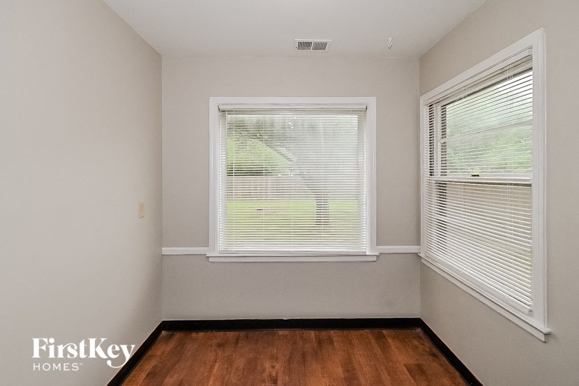an empty room with a window and a wood floor