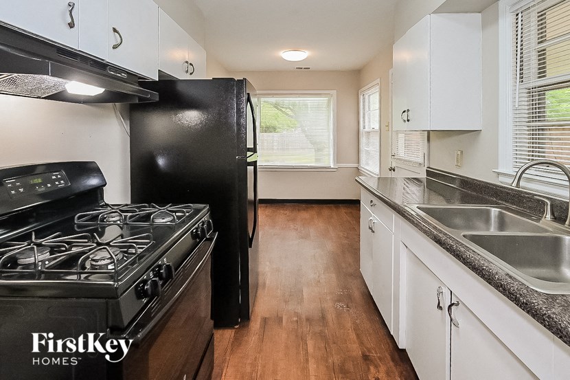a kitchen with a stove and a sink and a refrigerator