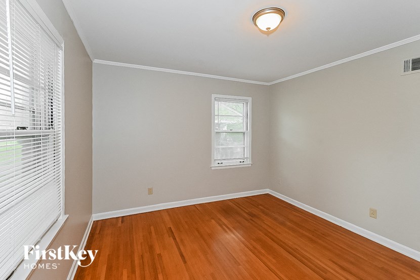 an empty room with wood floors and a window