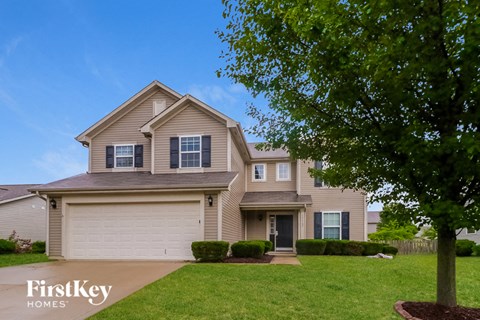 a beige house with a tree in front of it
