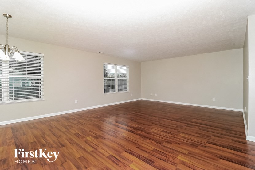 the living room of an empty house with wood flooring