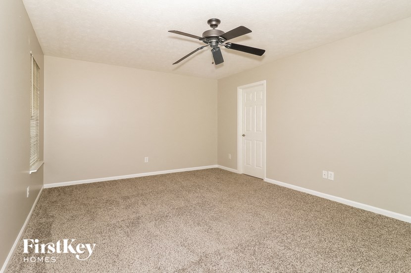 the living room of an empty house with a ceiling fan