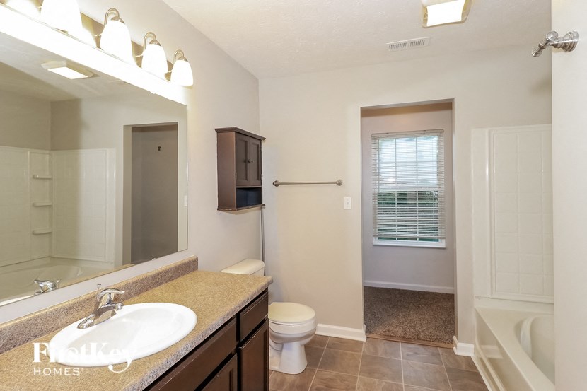 a bathroom with a large mirror and a sink and a toilet