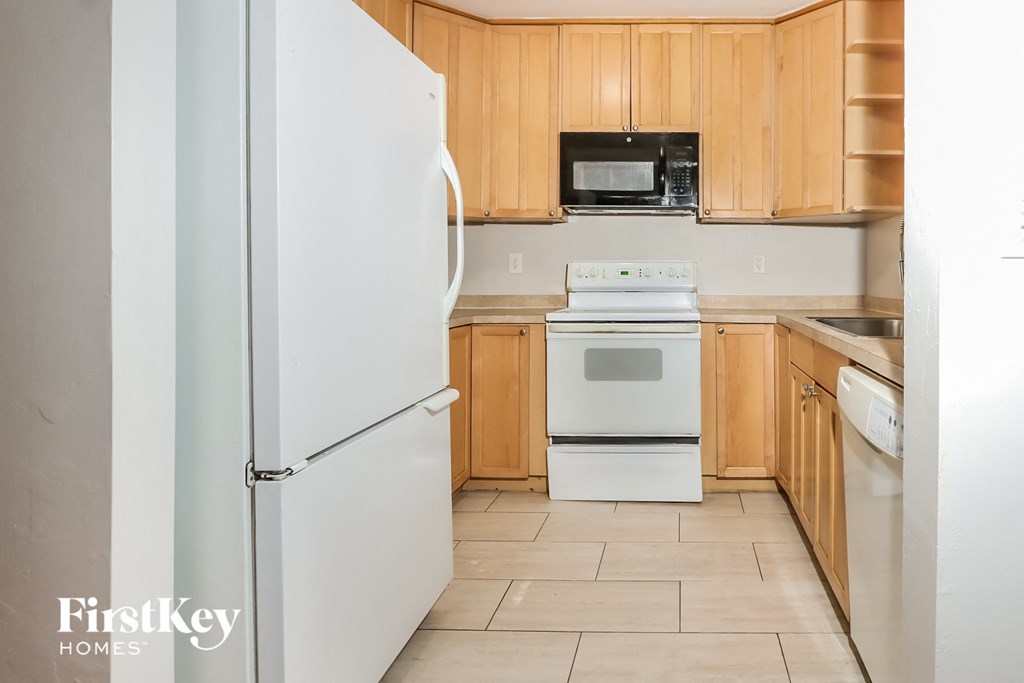 A kitchen with wooden cabinets and a white refrigerator.