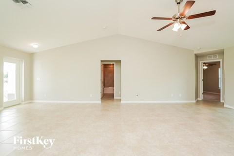 a large empty living room with a ceiling fan