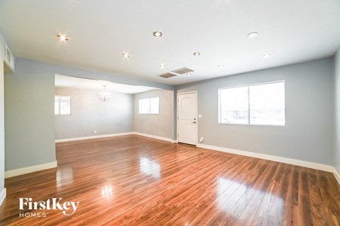 A spacious room with wooden floors and white walls.