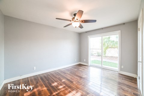 A room with a ceiling fan and wooden floors.