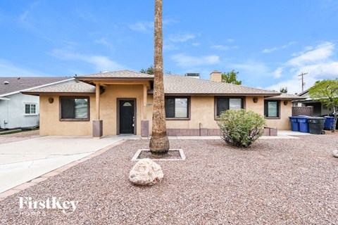 A house with a brown roof and tan walls is for sale.