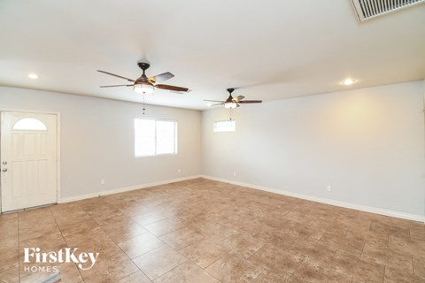 A room with a ceiling fan and a door.