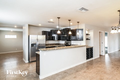 A kitchen with a white counter and a refrigerator.