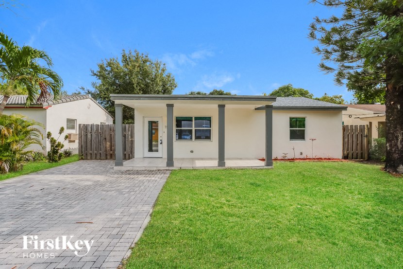 A house with a white exterior and a grey roof is for sale.