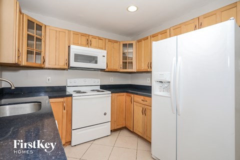 a kitchen with white appliances and wooden cabinets