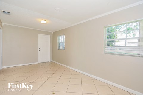 an empty living room with a door and a window