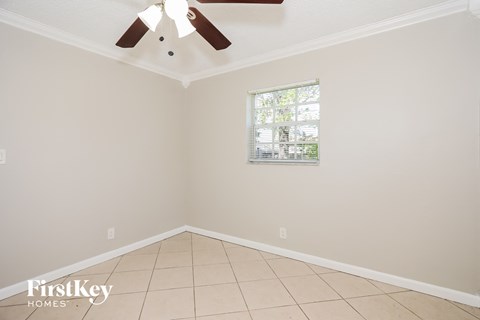 a empty room with a ceiling fan and a window
