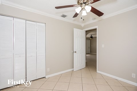 a bedroom with a ceiling fan and a closet