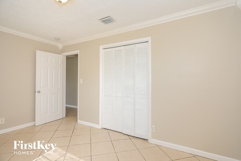 a room with a door and a closet and a tiled floor