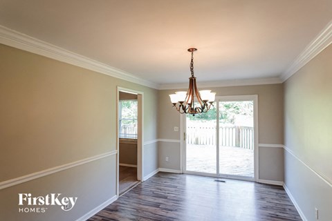 a dining room with a chandelier and a door to a deck