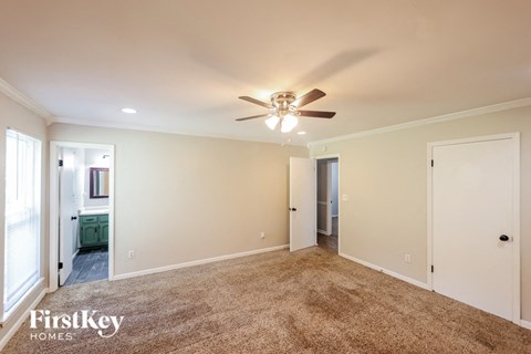 a living room with carpet and a ceiling fan