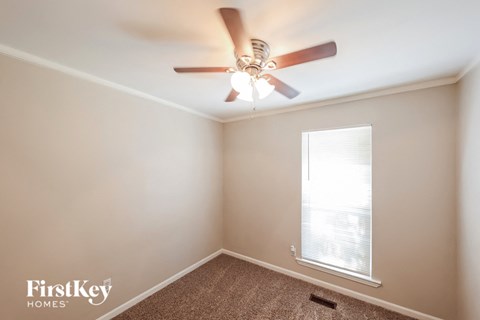 a bedroom with a ceiling fan and a window