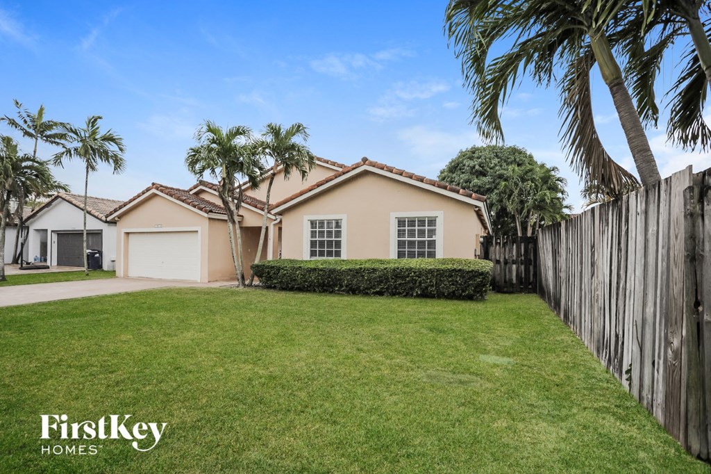 a home with a yard and palm trees