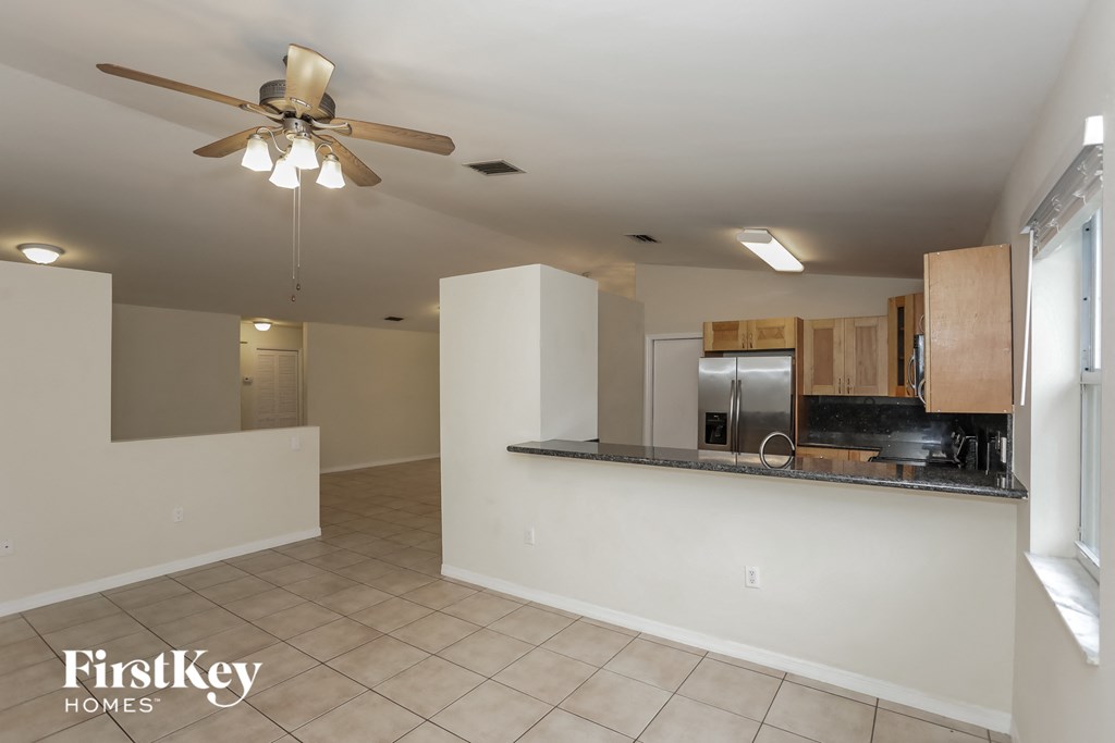 a kitchen and living room with a ceiling fan