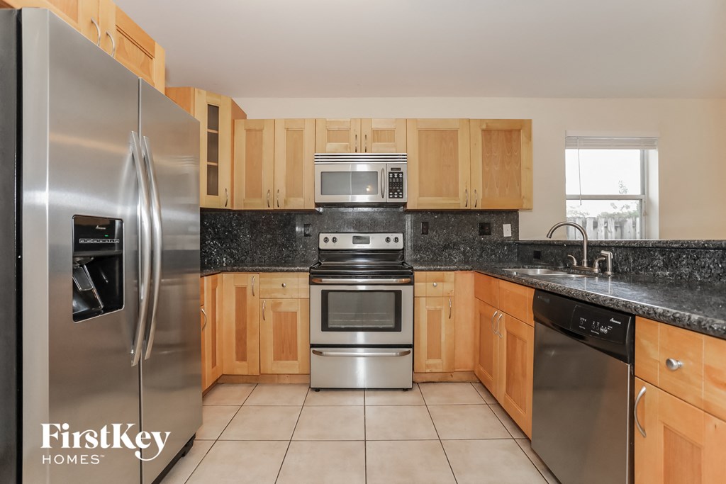 a kitchen with wooden cabinets and stainless steel appliances