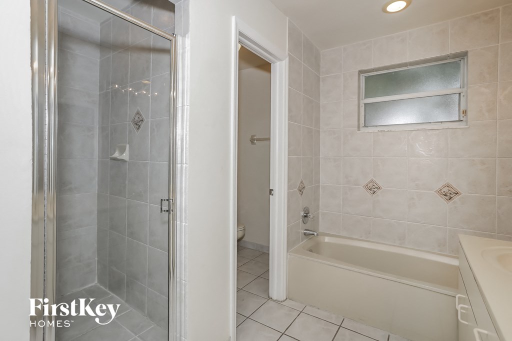 a bathroom with a shower and a tub and a sink