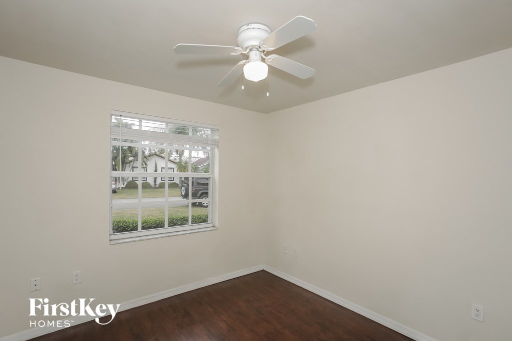 a bedroom with a ceiling fan and a window