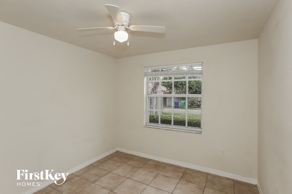 an empty room with a window and a ceiling fan
