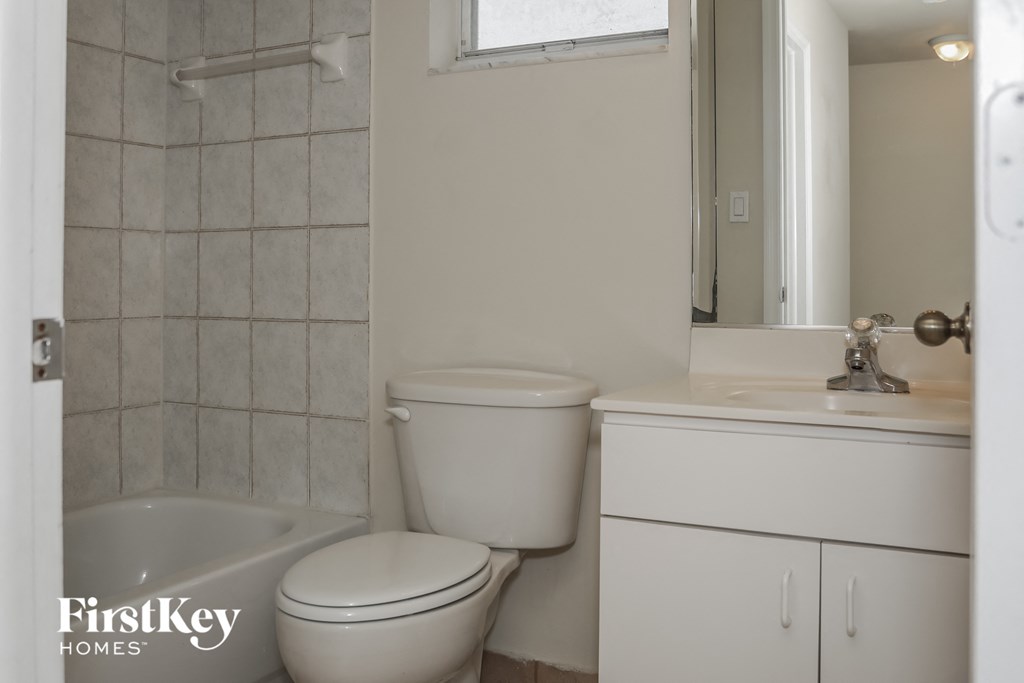 a bathroom with a toilet and a sink and a mirror