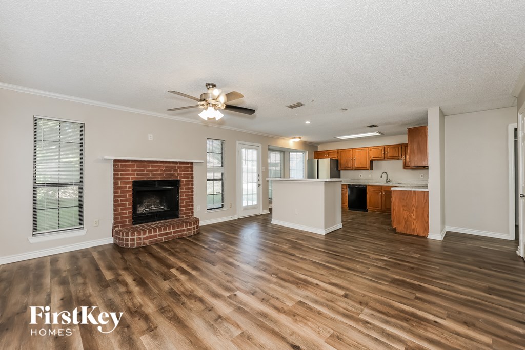 A spacious living room with a fireplace and wooden floors.