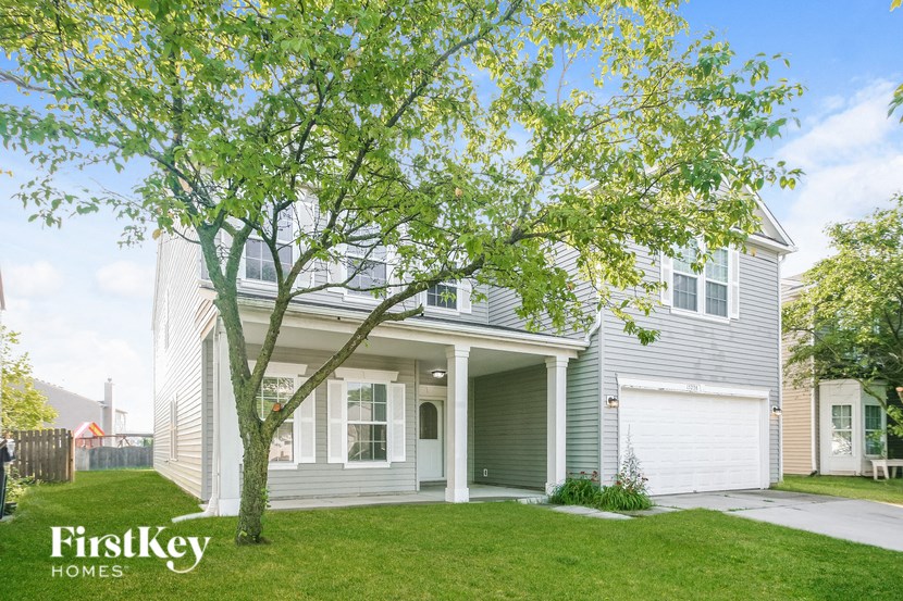a white and gray house with a tree in the yard