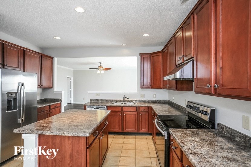 a kitchen with granite counter tops and wooden cabinets