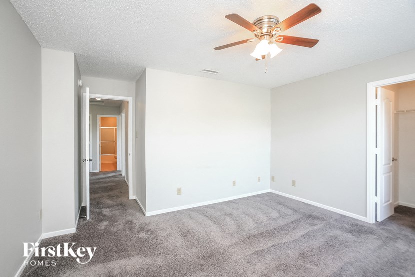 a living room with carpet and a ceiling fan