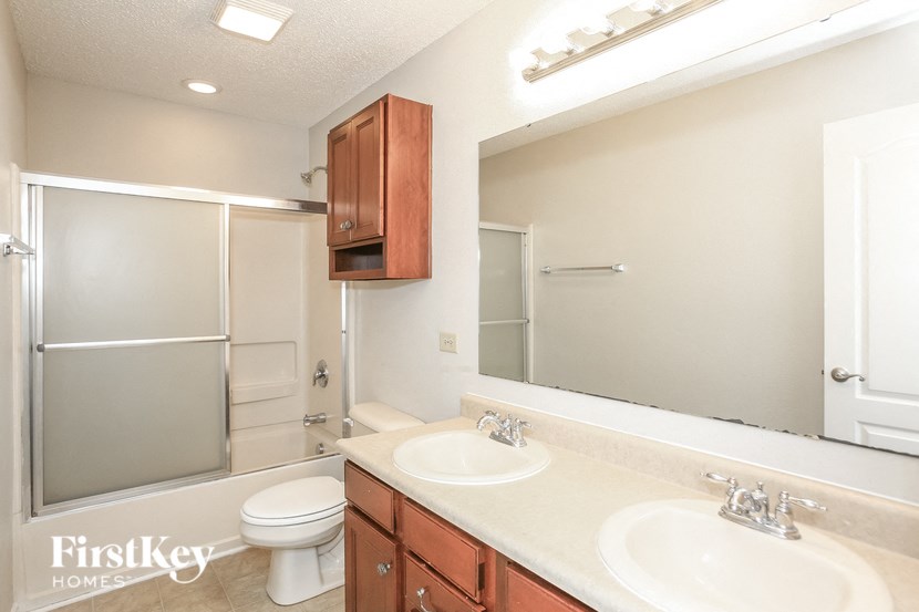 a bathroom with two sinks and a shower and a toilet