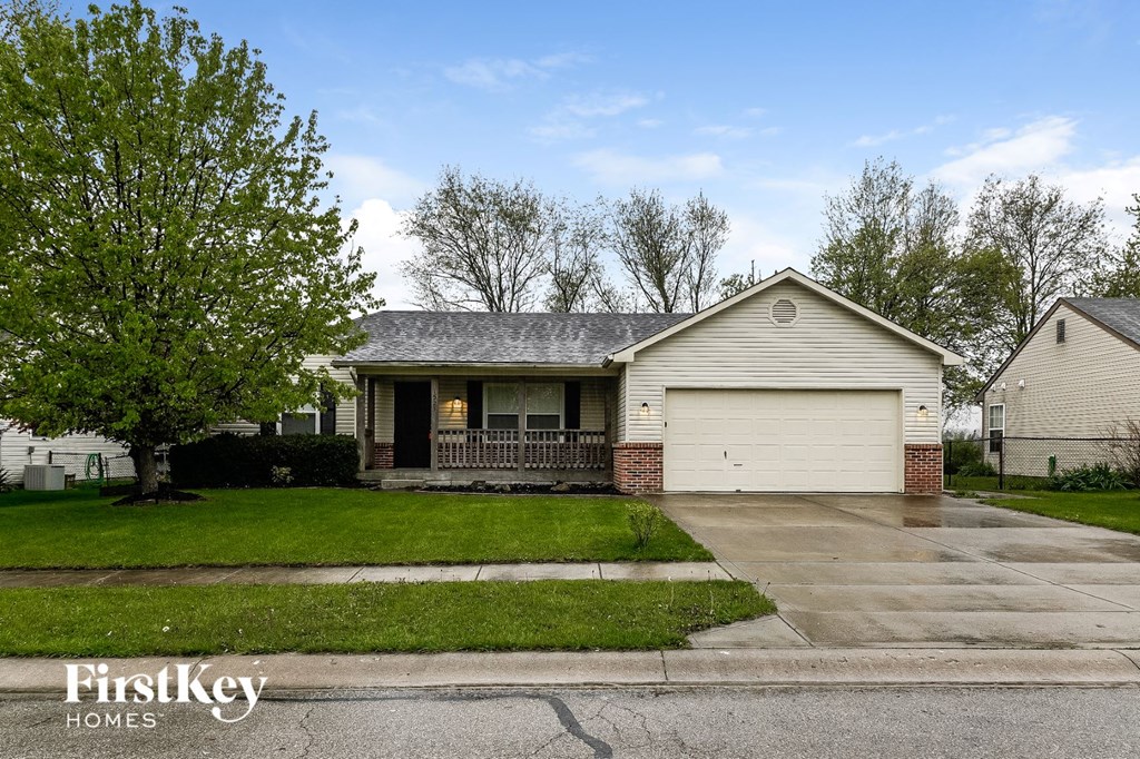 a white house with a yard and a tree