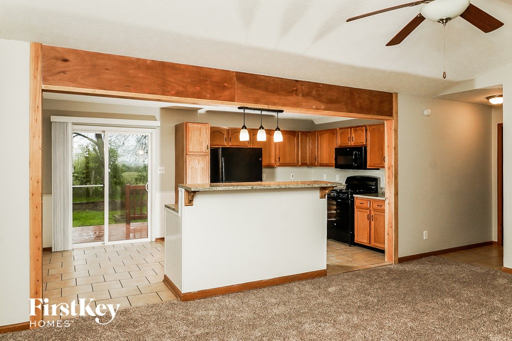 a kitchen with a white island and a door to a patio