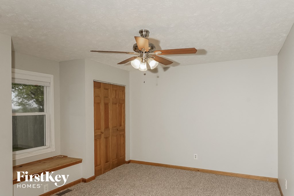 the master bedroom has a ceiling fan and a window