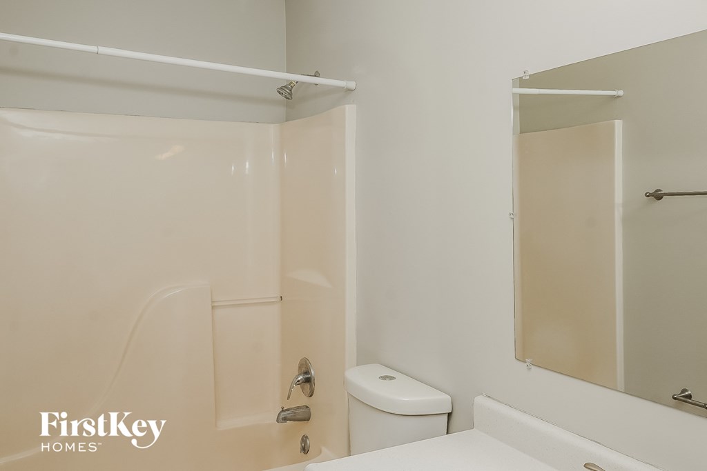 a bathroom with a shower and a toilet and a sink