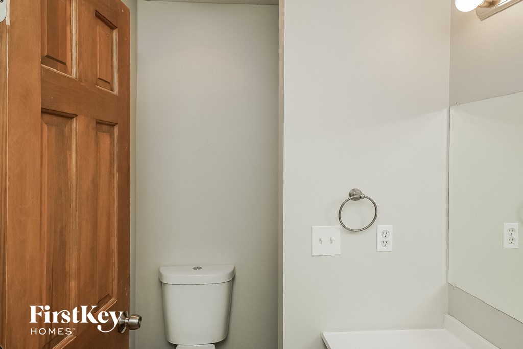 a bathroom with a toilet and a mirror and a door