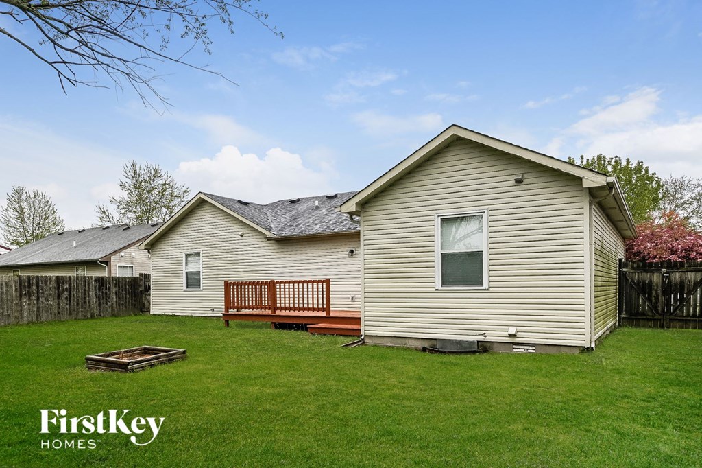 a backyard with a house and a wooden deck