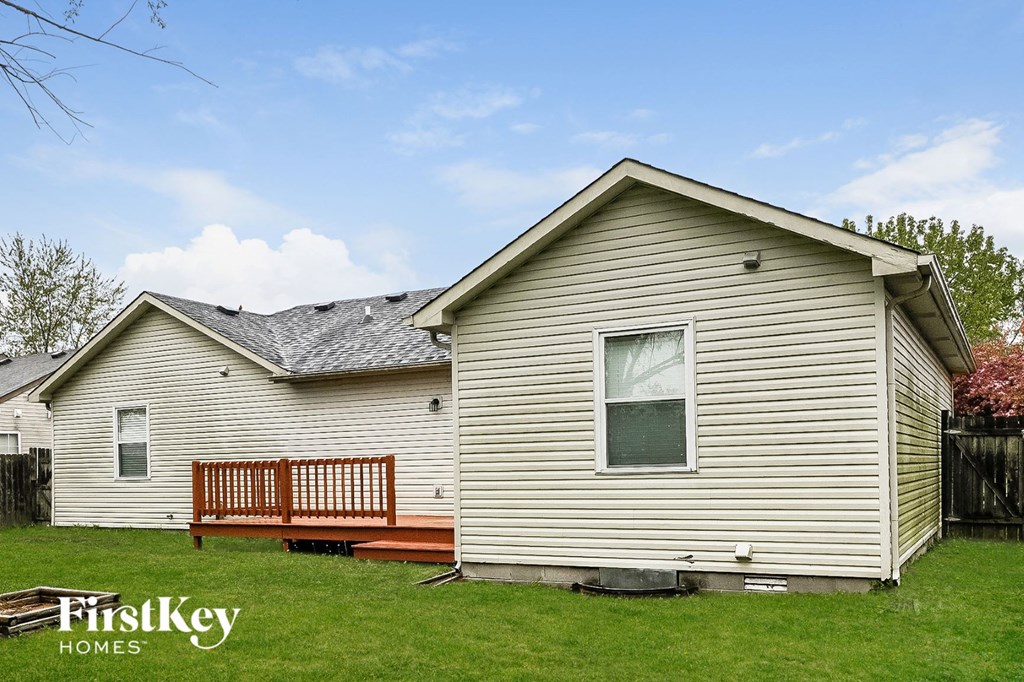 a small house with a deck in a yard