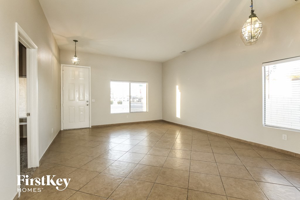 an empty living room with tile floors and white walls