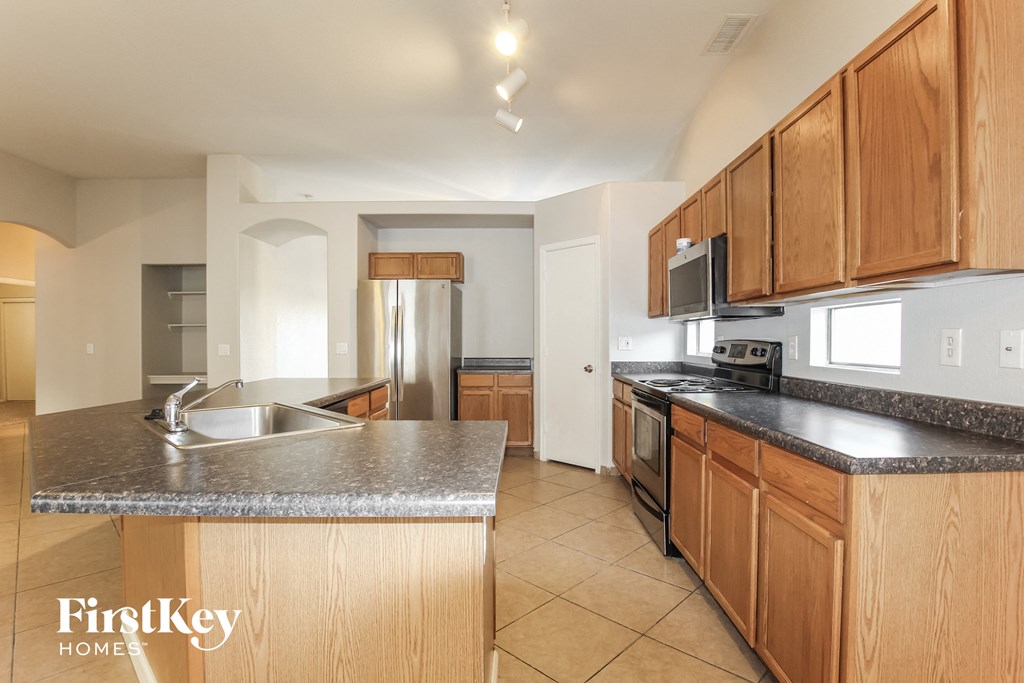 full kitchen with granite countertops and stainless steel appliances and wooden cabinets