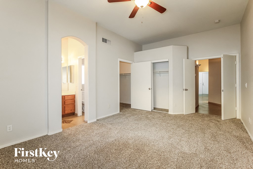 an empty living room with white walls and a ceiling fan