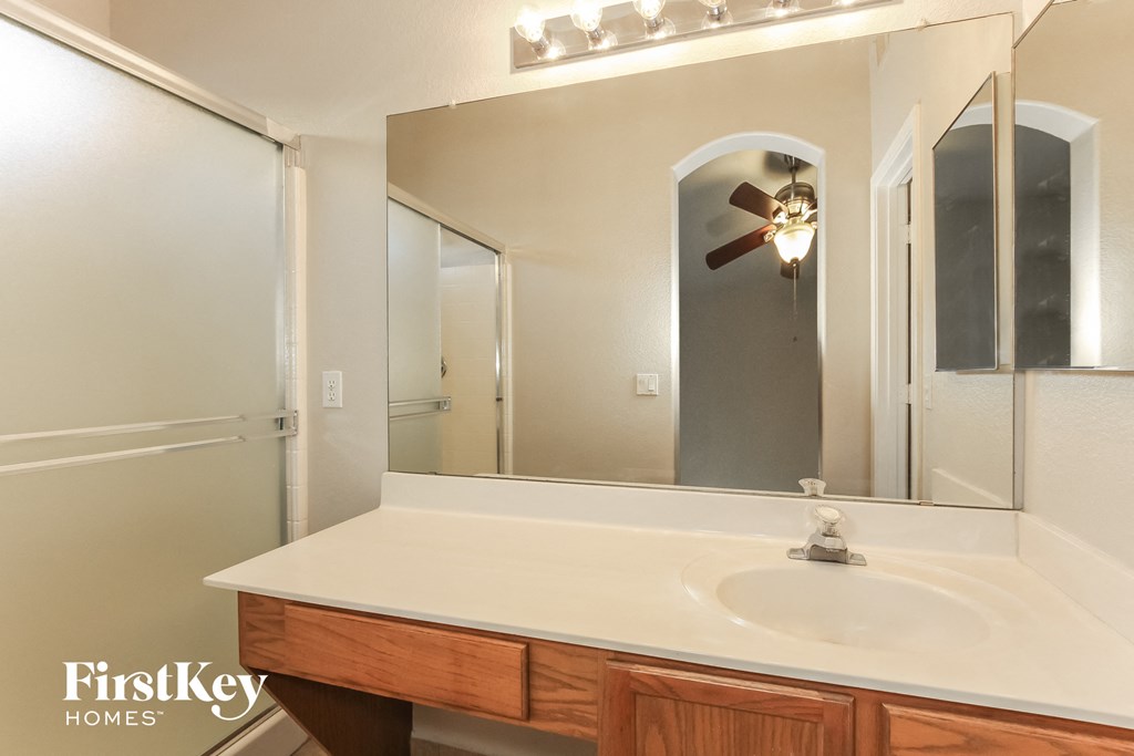 a bathroom with a white sink and a large mirror